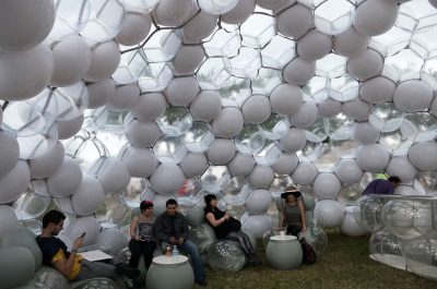 Photograph of an inflatable room with people sitting inside.